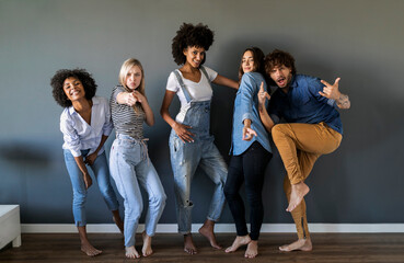 Group portrait of friends standing at a wall posing