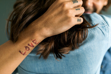 Close-up of tattooed man embracing girlfriend