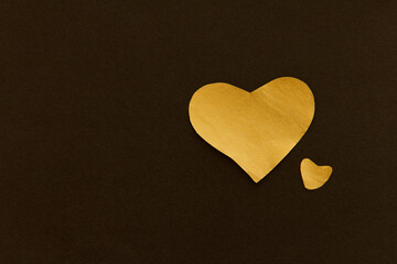 Two Golden sparkling heart on a black background, made of paper, romantic and festive beautiful symbol