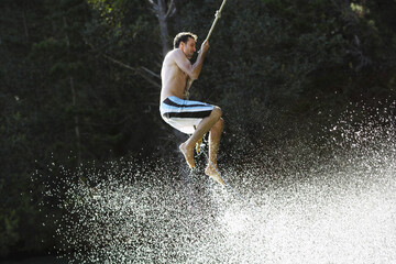 Man Swinging on Rope