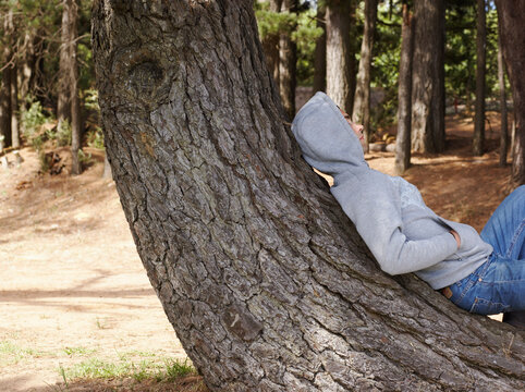 Man Lying Down on Tree Trunk