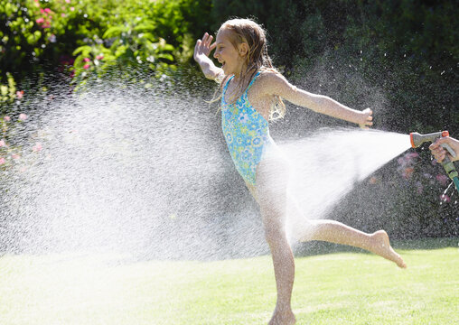 Girl Being sprayed With Garden Hose