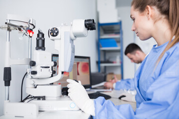 Lab technician working with microscope in lab