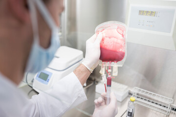 Scientist working with blood bag in lab