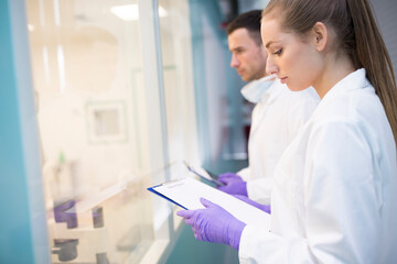 Man and woman in lab coats with clipboards