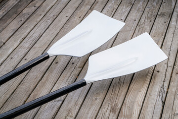 blades of hatchet sculling oars against grunge, rustic wooden deck