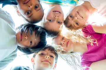 Group of children, sticking heads together, upward view