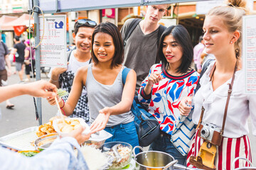 Thailand, Bangkok, Khao San Road, group of friends testing local food on street market
