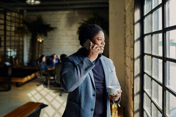 Young businessman having phone call on coffee break in office