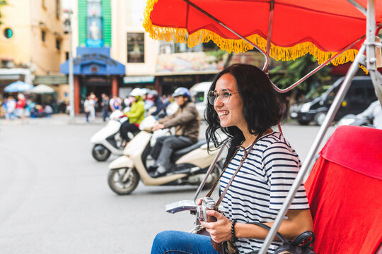 Vietnam, Hanoi, happy young woman on a riksha exploring the city