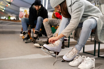 Friends putting on ice skates at an ice rink
