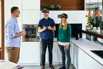 Couple wearing VR glasses shopping for a new kitchen in showroom