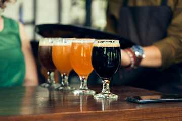 Waiter serving variety of craft beer in a pub