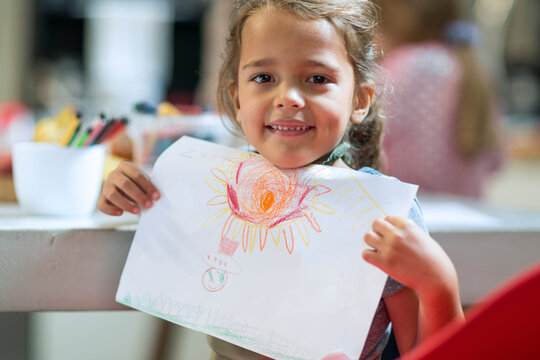 Smiling girl showing drawing