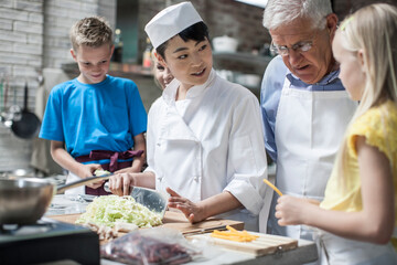 Female chef instructing kids in cooking class