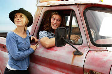 Smiling young couple with an old pick up