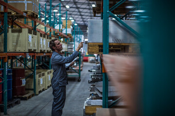 Worker in factory warehouse taking stock