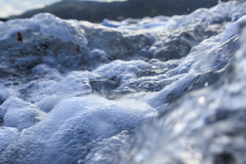 The sea in blue and green colors with crashing waves on a stormy day in Agios Georgios on the island of Corfu