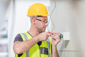 Electrician screwing in wire on construction site