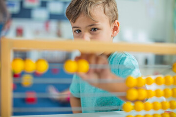 Boy in kindergarten using abacus