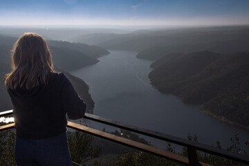 A girl at the top of the Monfragüe Castle contemplates the landscape of the National Park with its...