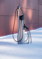 EV charging station for zero emission cars in white snow pile