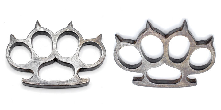Old metal brass knuckles knuckledusters with spikes isolated on white background injuries, street fights, fights without rules, urban crime. German World War Two military era showing marks scrapes