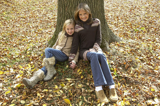 Portrait of Girls Sitting in Front of Tree, in Autumn