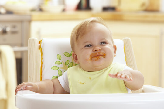 Baby with Messy Face in High Chair