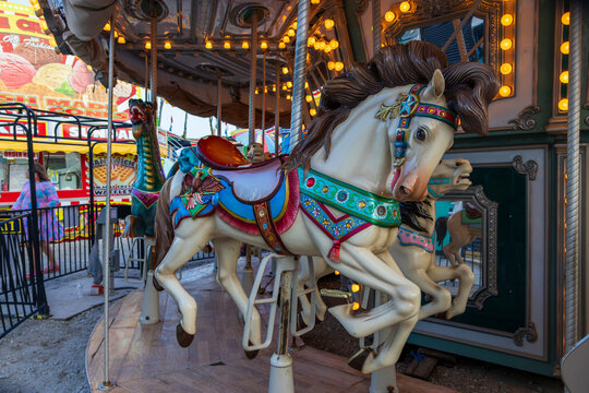 A Merry-go-round with horses and seahorses with colorful lights and carnival rides along the boardwalk at the Carolina Beach Boardwalk in Carolina Beach North Carolina USA