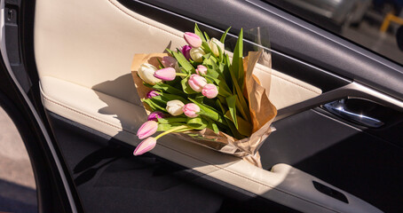 bouquet of spring pink tulips in the car door.