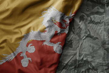 waving flag of bhutan on the old khaki texture background. military concept.