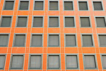facade of a new brick building with closed windows and lowered blinds close-up