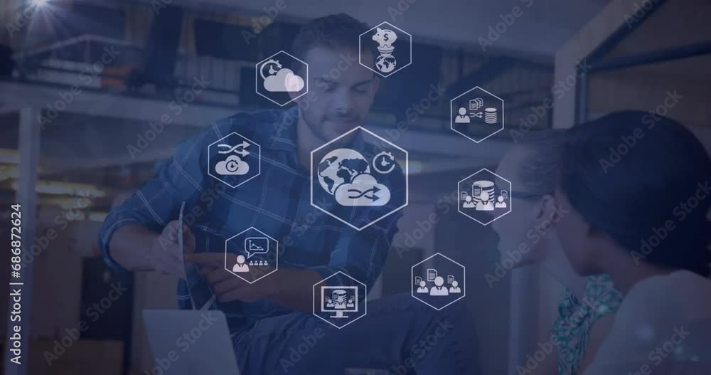 Poster animation of icon in hexagons over diverse coworkers discussing reports on desk in office