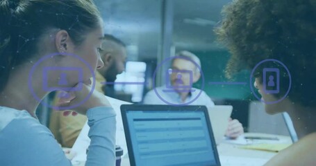 Animation of flowchart of icons over diverse female coworkers discussing reports on laptop in office - Powered by Adobe