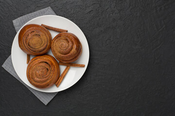 Sweet homemade cinnamon rolls on concrete background, top view