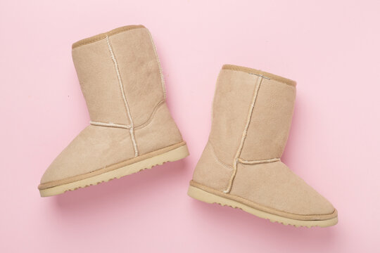 Beautiful woman ugg boots on color background,top view