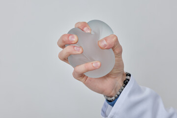 Professional plastic surgeon showing quality of silicone breast implant, mastopexy concept, BREAST...
