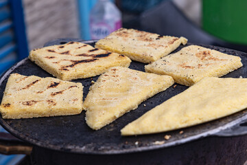 Flat bread being grilled at an outdoor market.