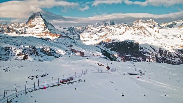 Aerial view of Zermatt Matterhorn and Gornergrat Railway during winter in Switzerland. View from above of a train transporting tourists and people skiing The Alpine mountain.