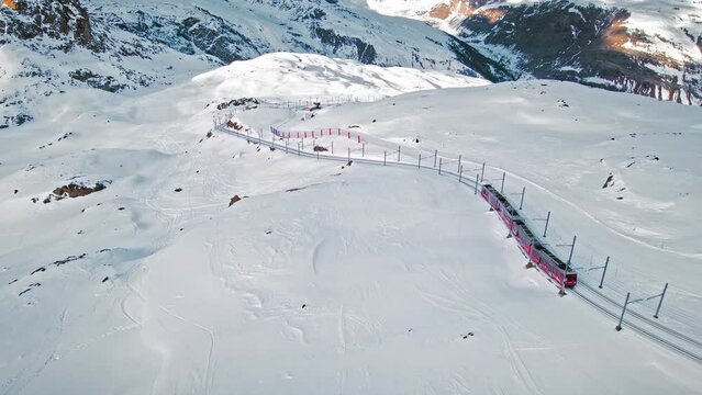 View from above of the Swiss train on the Gornergrat Railway. Aerial view of tourists skiing at Zermatt Matterhorn during winter vacation in Switzerland.