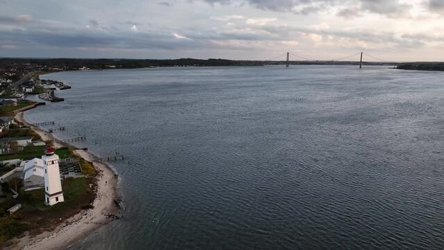 Aerial footage of Strib Lighthouse and bridge over Danish strait between island of Funen and Jutland. Beacon on the Danish coast and bridge Den Nye Lilleb&aelig;ltsbro (The New Little Belt Bridge).