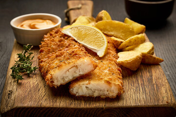 breaded fish fillets and fried potato wedges - 686898271