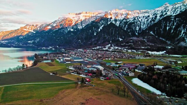 Aerial view of Interlaken Resort Town in Switzerland and turquoise Lake Brienz. Panoramic sunset landscape of the residential Swiss houses by Alps Mountains in Europe