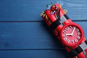 Dynamite time bomb on blue wooden table, top view. Space for text