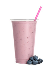 Plastic cup of tasty smoothie and fresh blueberries isolated on white
