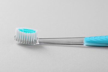 One plastic toothbrush on light background, closeup