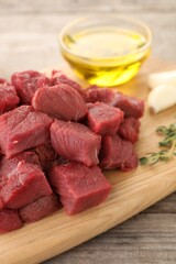 Pieces of raw beef meat on wooden table, closeup