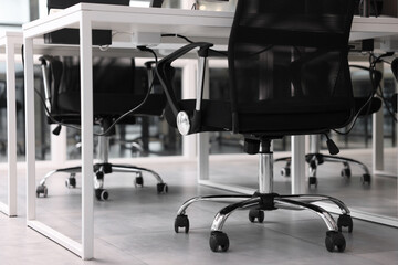 Comfortable office chairs and tables in meeting room, closeup