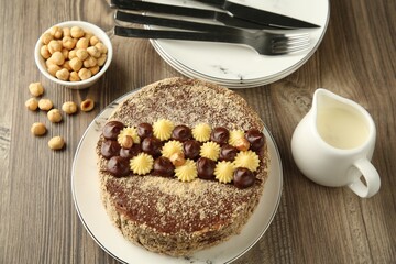 Delicious Kyiv Cake with cream and hazelnuts served on wooden table